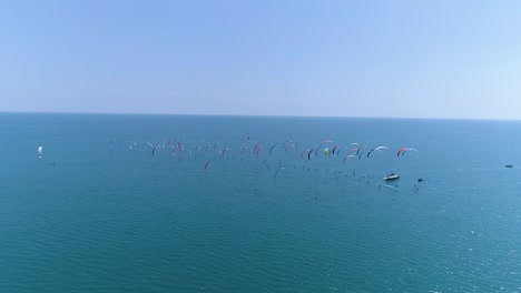 Group-of-kitesurfers-racing,-view-from-behind-by-drone.